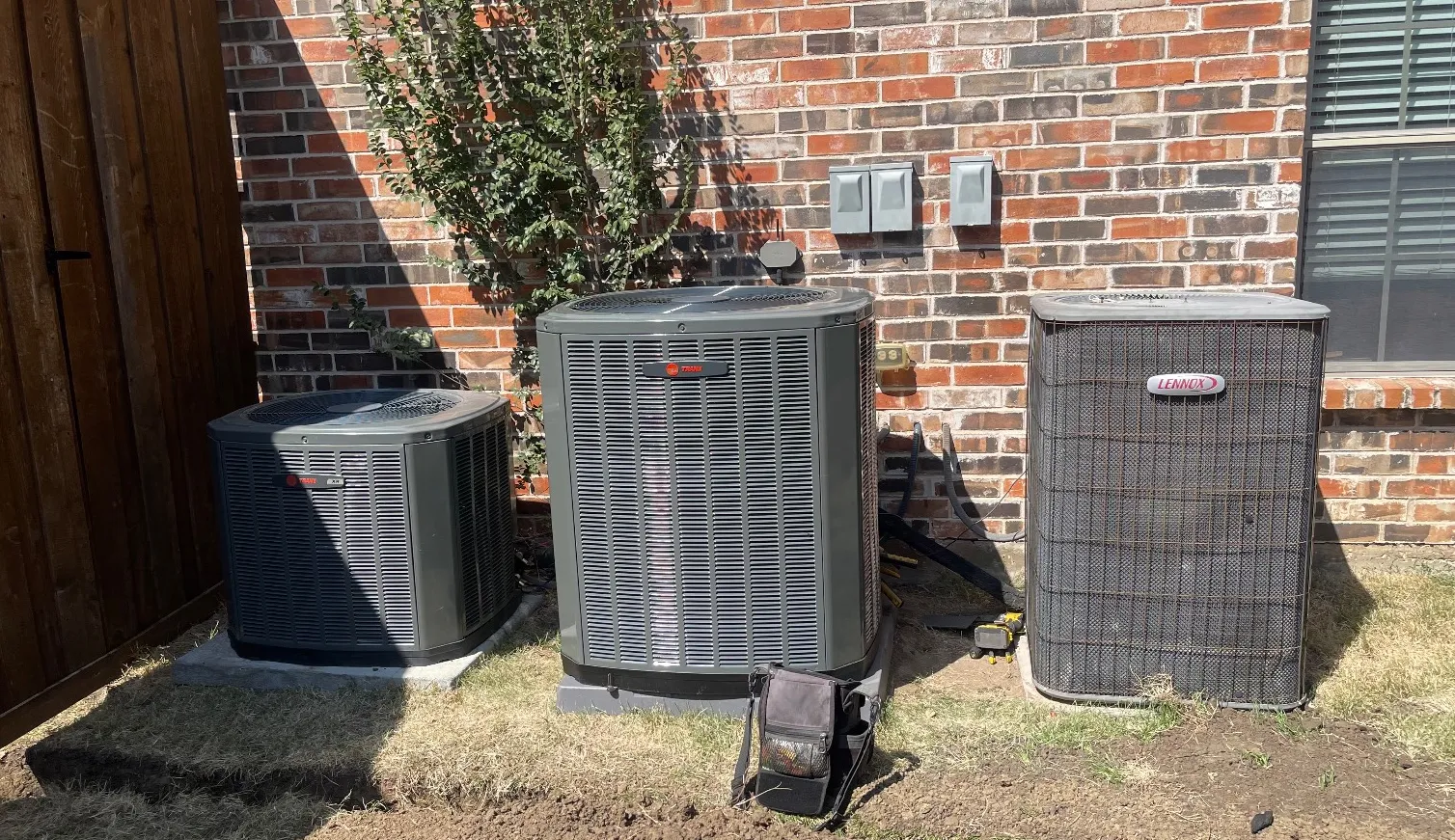 Three outdoor condensing units installed side by side at a Flower Mound home